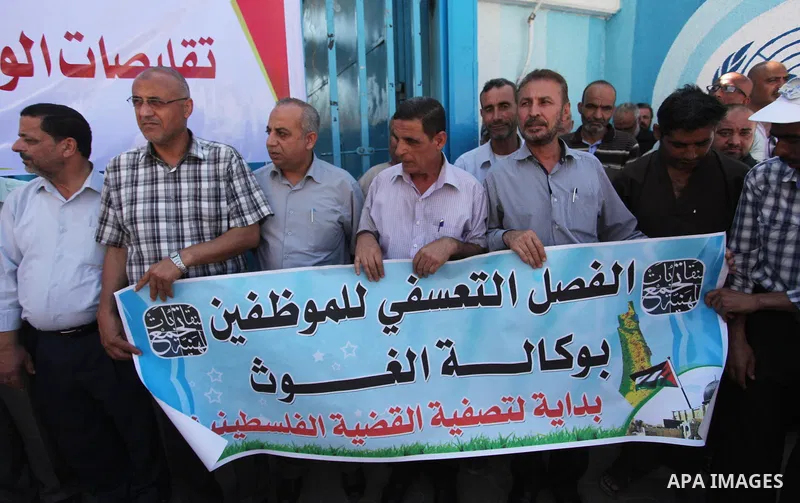 Palestinians hold banners during a protest against a U.S. decision to cut aid, in front of the headquarters United Nations Relief and Works Agency (UNRWA), in Gaza City, on August 6, 2018. Photo by Mahmoud Ajour