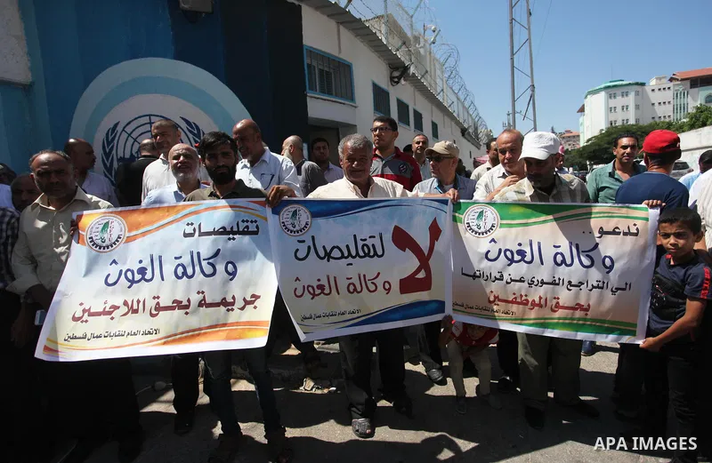 Palestinians hold banners during a protest against a U.S. decision to cut aid, in front of the headquarters United Nations Relief and Works Agency (UNRWA), in Gaza City, on August 6, 2018. Photo by Mahmoud Ajour