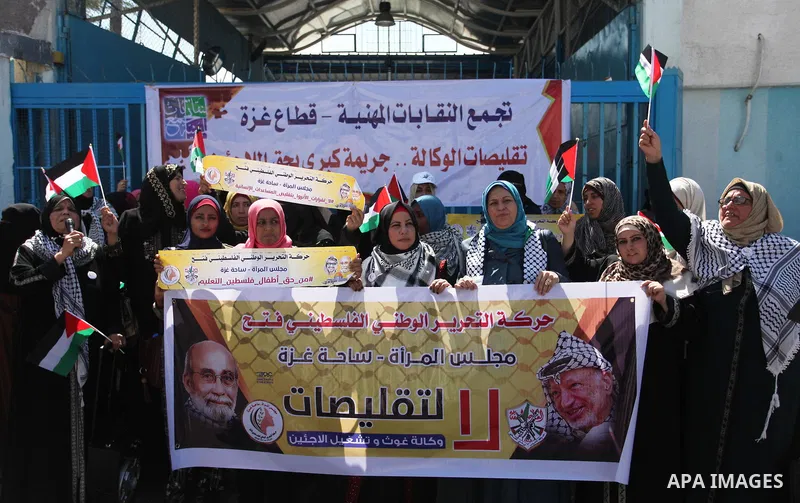 Palestinians hold banners during a protest against a U.S. decision to cut aid, in front of the headquarters United Nations Relief and Works Agency (UNRWA), in Gaza City, on August 6, 2018. Photo by Mahmoud Ajour