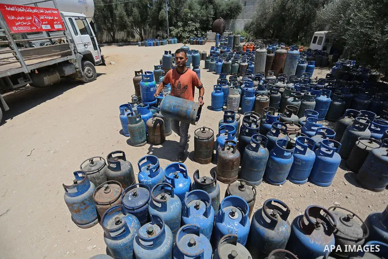 A Palestinian worker carries a gas cylinder at a gas station in Khan Younis in the southern of Gaza strip on August 6, 2018. Egypt has allowed domestic gas deliveries into the blockaded Gaza Strip for the first time, acc...