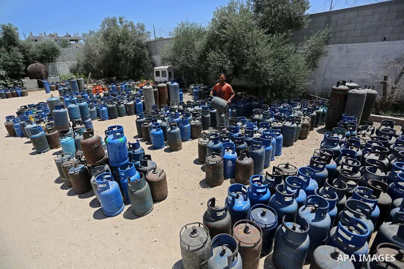 A Palestinian worker carries a gas cylinder at a gas station in Khan Younis in the southern of Gaza strip on August 6, 2018. Egypt has allowed domestic gas deliveries into the blockaded Gaza Strip for the first time, acc...