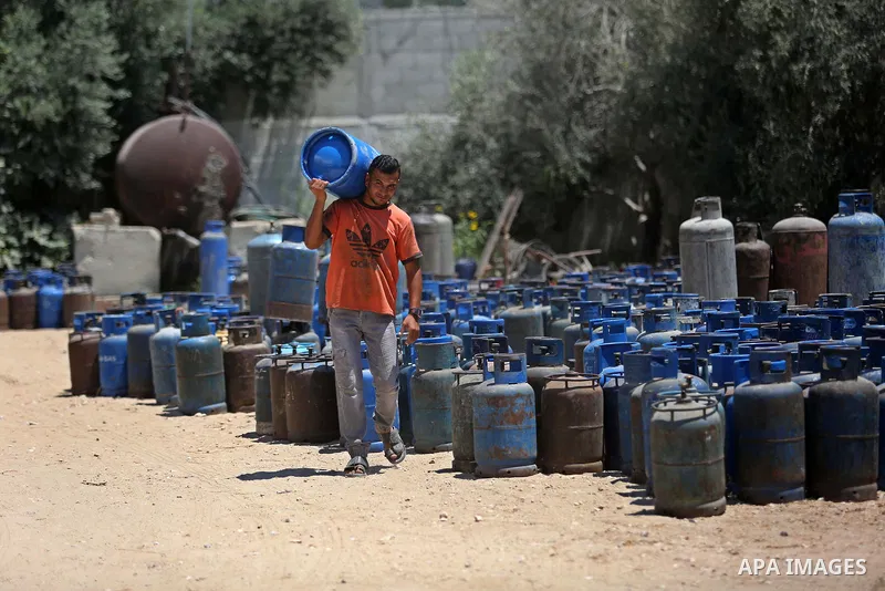 A Palestinian worker carries a gas cylinder at a gas station in Khan Younis in the southern of Gaza strip on August 6, 2018. Egypt has allowed domestic gas deliveries into the blockaded Gaza Strip for the first time, acc...