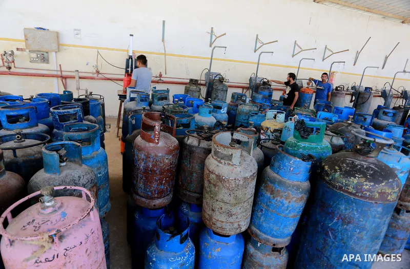 A Palestinian worker waits to fill cylinders with cooking gas imported from Egypt, at a gas station in Rafah, in the southern Gaza Strip on August 6, 2018. Egypt has allowed domestic gas deliveries into the blockaded Gaz...
