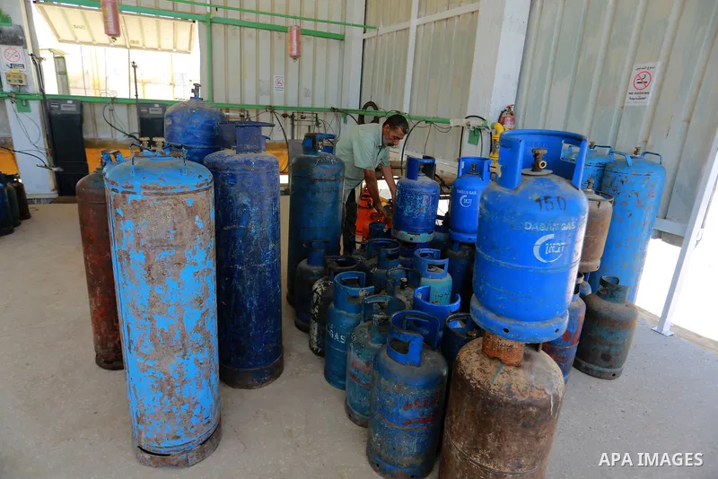 A Palestinian worker waits to fill cylinders with cooking gas imported from Egypt, at a gas station in Rafah, in the southern Gaza Strip on August 6, 2018. Egypt has allowed domestic gas deliveries into the blockaded Gaz...
