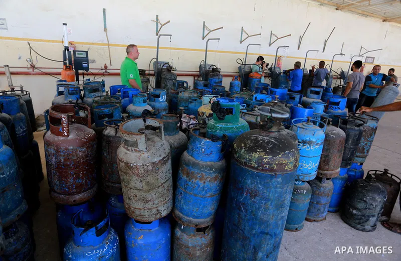 A Palestinian worker waits to fill cylinders with cooking gas imported from Egypt, at a gas station in Rafah, in the southern Gaza Strip on August 6, 2018. Egypt has allowed domestic gas deliveries into the blockaded Gaz...