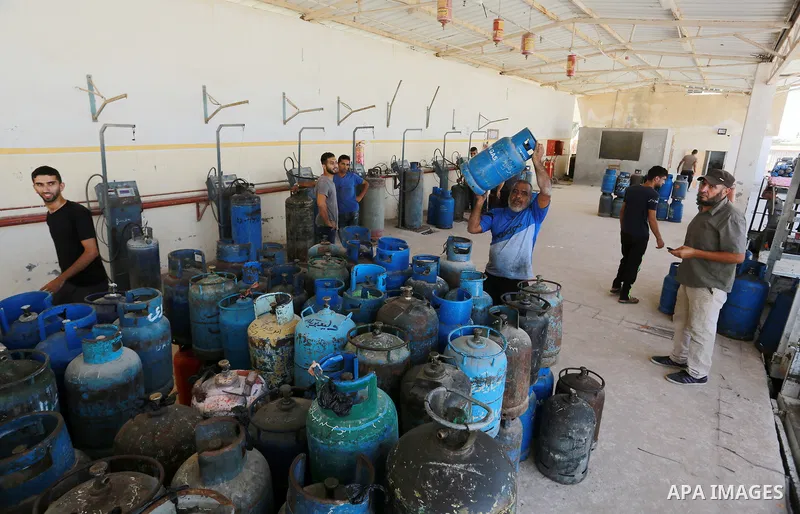 A Palestinian worker waits to fill cylinders with cooking gas imported from Egypt, at a gas station in Rafah, in the southern Gaza Strip on August 6, 2018. Egypt has allowed domestic gas deliveries into the blockaded Gaz...