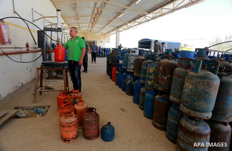 A Palestinian worker waits to fill cylinders with cooking gas imported from Egypt, at a gas station in Rafah, in the southern Gaza Strip on August 6, 2018. Egypt has allowed domestic gas deliveries into the blockaded Gaz...