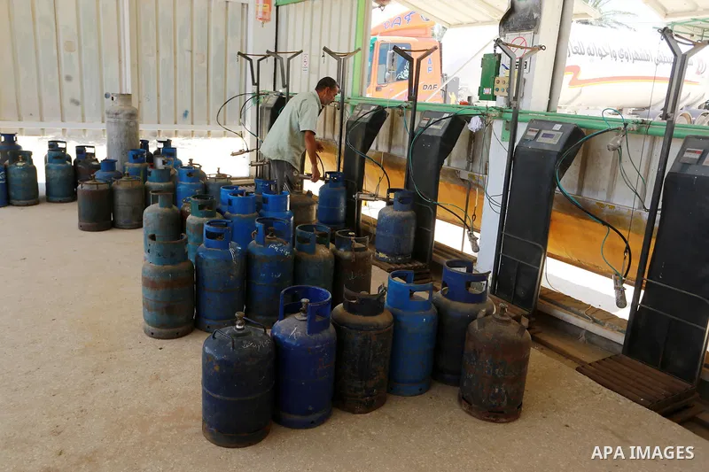 A Palestinian worker waits to fill cylinders with cooking gas imported from Egypt, at a gas station in Rafah, in the southern Gaza Strip on August 6, 2018. Egypt has allowed domestic gas deliveries into the blockaded Gaz...