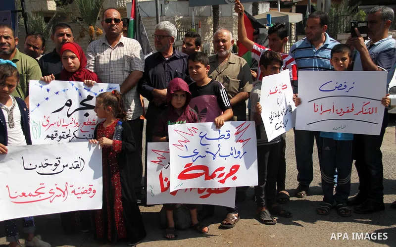 Palestinians take part in a protest to show solidarity with Palestinian prisoners are paid their salaries in Israeli jails in front of the Council of Ministers headquarter in Gaza City, on August 7, 2018. Photo by Mahmou...