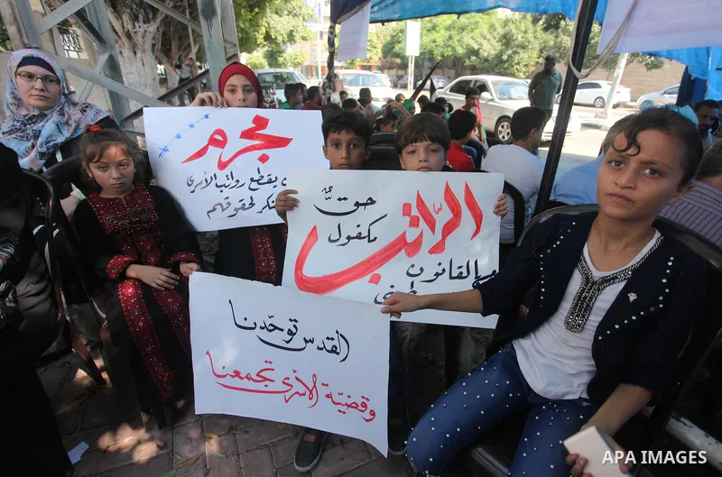 Palestinians take part in a protest to show solidarity with Palestinian prisoners are paid their salaries in Israeli jails in front of the Council of Ministers headquarter in Gaza City, on August 7, 2018. Photo by Mahmou...