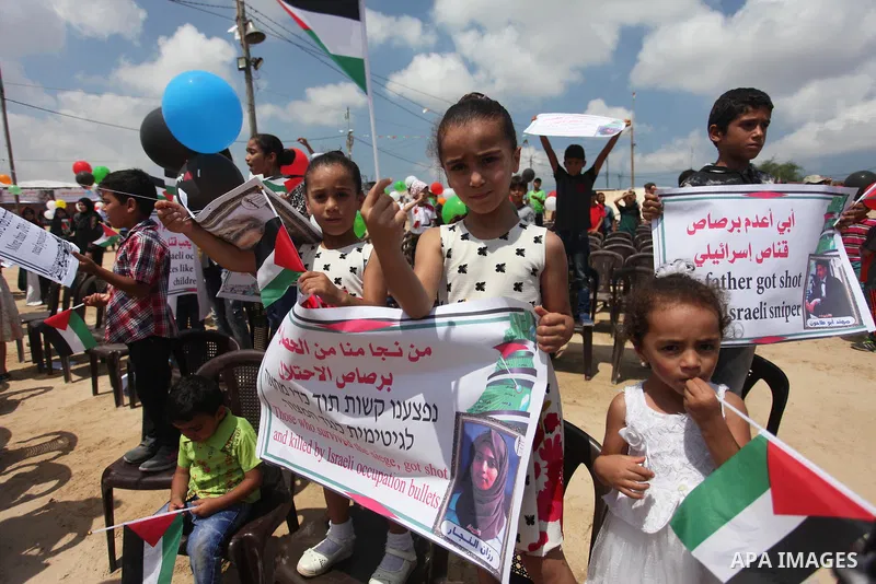 Palestinian children hold balloons before it be fly during a protest to break Israel's blockade on Gaza Strip near tents at Gaza-Israel border, in east of Gaza city on August 7, 2018. Photo by Mahmoud Ajour