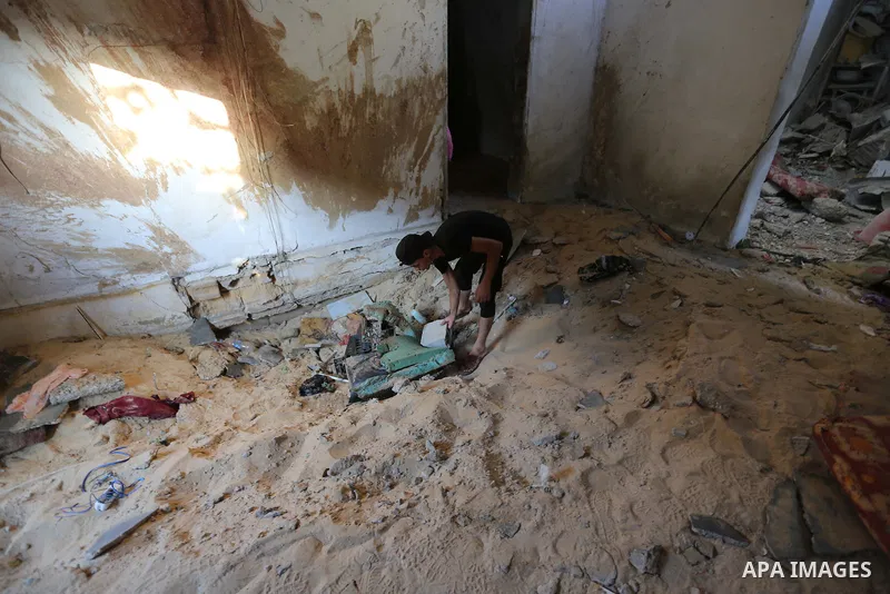 Palestinians inspect a house that was damaged in an Israeli airstrike on Dair al Balah in the center of Gaza Strip on August 9, 2018. Photo by Ashraf Amra