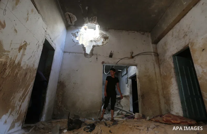 Palestinians inspect a house that was damaged in an Israeli airstrike on Dair al Balah in the center of Gaza Strip on August 9, 2018. Photo by Ashraf Amra