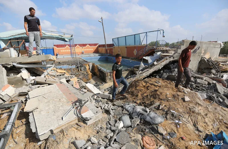Palestinians inspect a swimming pool that was damaged in an Israeli airstrike in Khan Younis in the southern of Gaza Strip on August 9, 2018. Photo by Ashraf Amra