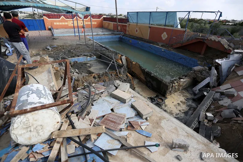 Palestinians inspect a swimming pool that was damaged in an Israeli airstrike in Khan Younis in the southern of Gaza Strip on August 9, 2018. Photo by Ashraf Amra