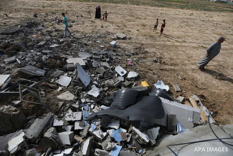 Palestinians inspect a swimming pool that was damaged in an Israeli airstrike in Khan Younis in the southern of Gaza Strip on August 9, 2018. Photo by Ashraf Amra