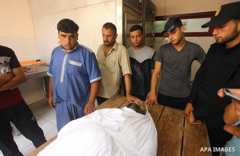 Relatives of Palestinian Hamas militant Ali al-Ghandour who was killed in an Israeli airstrike, mourn over his body during his funeral in the northern of Gaza Strip on August 9, 2018. Photo by Mahmoud Ajour