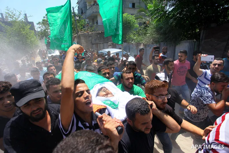 Mourners carry the body of Palestinian Hamas militant Ali al-Ghandour who was killed in an Israeli airstrike, during his funeral in the northern of Gaza Strip on August 9, 2018. Photo by Mahmoud Ajour