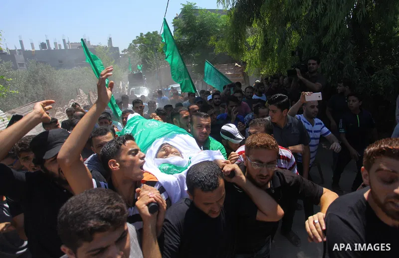 Mourners carry the body of Palestinian Hamas militant Ali al-Ghandour who was killed in an Israeli airstrike, during his funeral in the northern of Gaza Strip on August 9, 2018. Photo by Mahmoud Ajour
