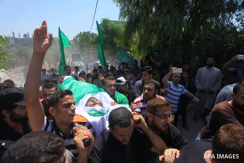 Mourners carry the body of Palestinian Hamas militant Ali al-Ghandour who was killed in an Israeli airstrike, during his funeral in the northern of Gaza Strip on August 9, 2018. Photo by Mahmoud Ajour
