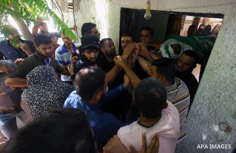 Mourners carry the body of Palestinian Hamas militant Ali al-Ghandour who was killed in an Israeli airstrike, during his funeral in the northern of Gaza Strip on August 9, 2018. Photo by Mahmoud Ajour