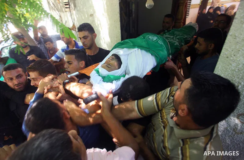Mourners carry the body of Palestinian Hamas militant Ali al-Ghandour who was killed in an Israeli airstrike, during his funeral in the northern of Gaza Strip on August 9, 2018. Photo by Mahmoud Ajour