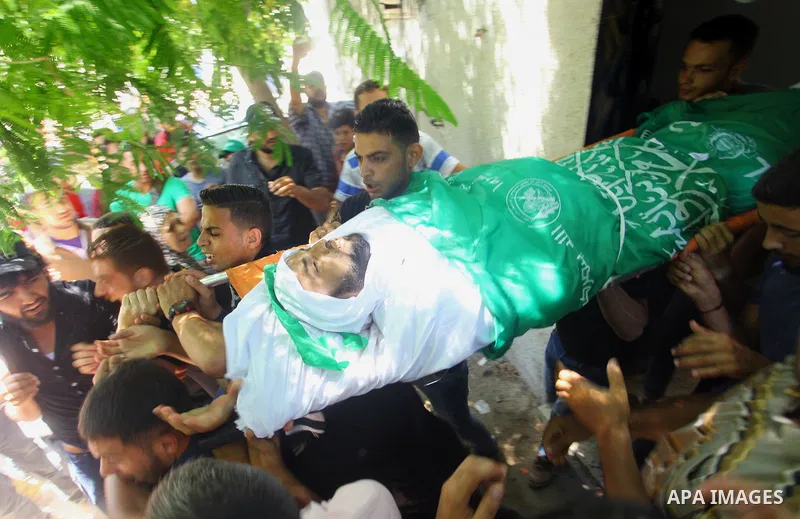 Mourners carry the body of Palestinian Hamas militant Ali al-Ghandour who was killed in an Israeli airstrike, during his funeral in the northern of Gaza Strip on August 9, 2018. Photo by Mahmoud Ajour