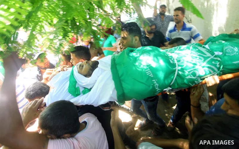 Mourners carry the body of Palestinian Hamas militant Ali al-Ghandour who was killed in an Israeli airstrike, during his funeral in the northern of Gaza Strip on August 9, 2018. Photo by Mahmoud Ajour