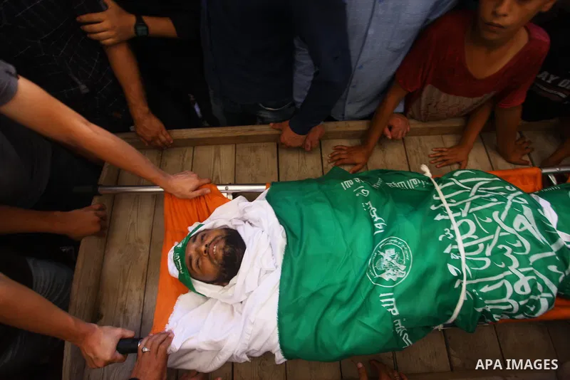 Relatives of Palestinian Hamas militant Ali al-Ghandour who was killed in an Israeli airstrike, mourn over his body during his funeral in the northern of Gaza Strip on August 9, 2018. Photo by Mahmoud Ajour