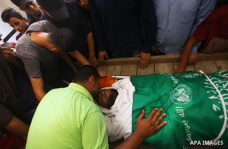 Relatives of Palestinian Hamas militant Ali al-Ghandour who was killed in an Israeli airstrike, mourn over his body during his funeral in the northern of Gaza Strip on August 9, 2018. Photo by Mahmoud Ajour