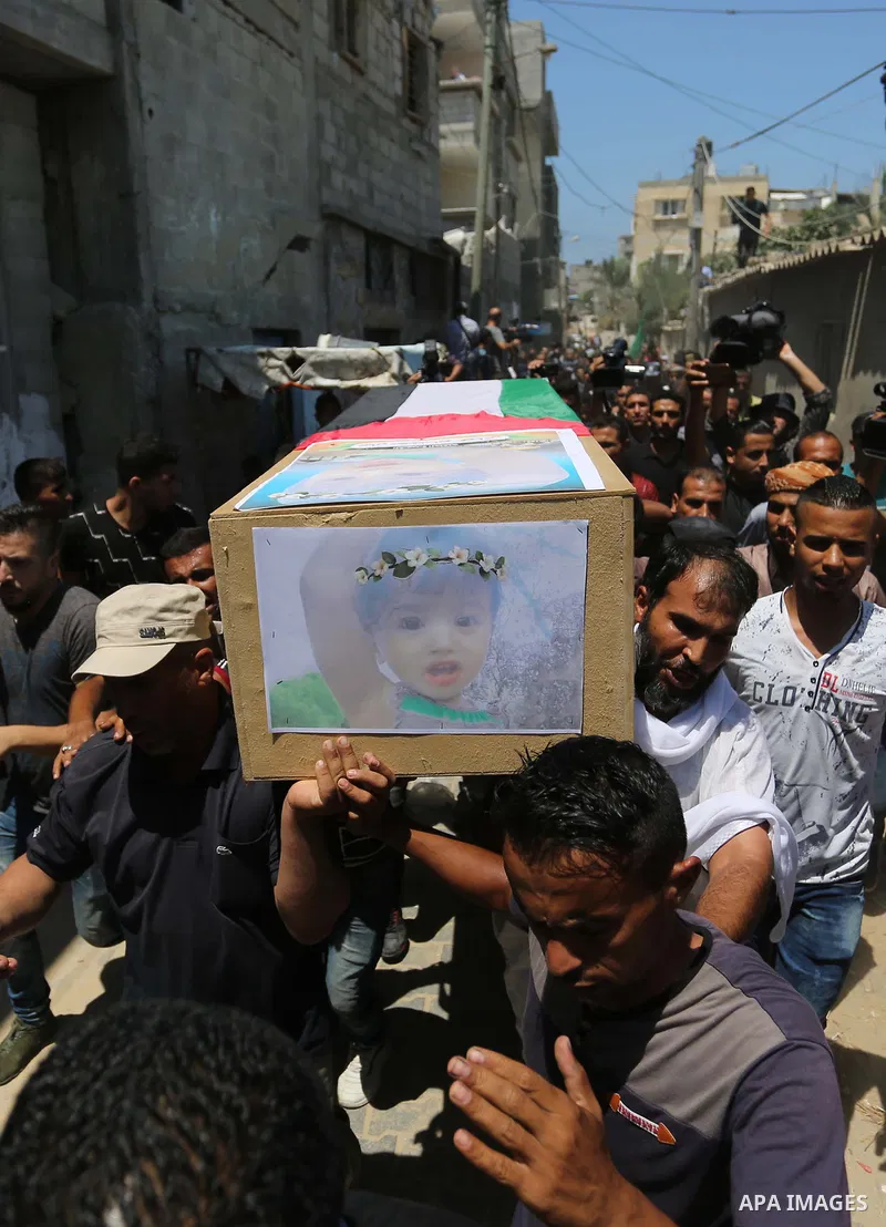 Mourners carry the bodies of Palestinian Enas Khammash 23, and her 18-month-daughter Bayan, during their funeral in Deir Al-Balah in the central Gaza Strip on August 9, 2018, who were killed earlier in an Israeli airstri...