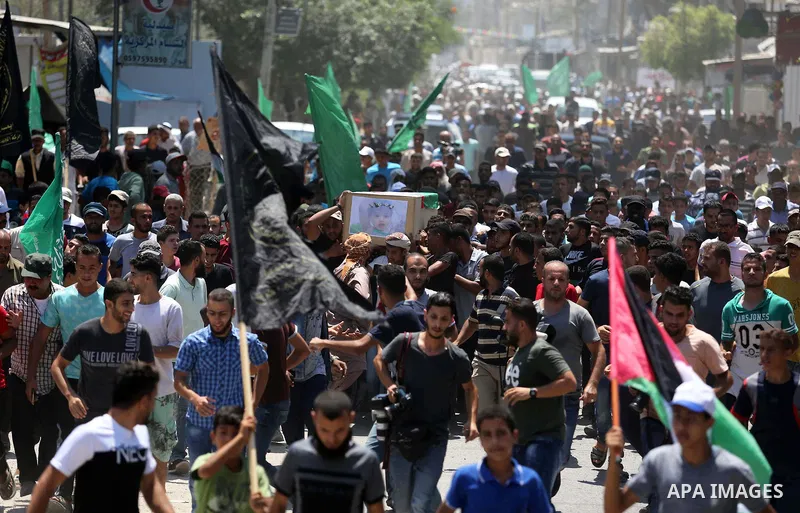 Mourners carry the bodies of Palestinian Enas Khammash 23, and her 18-month-daughter Bayan, during their funeral in Deir Al-Balah in the central Gaza Strip on August 9, 2018, who were killed earlier in an Israeli airstri...