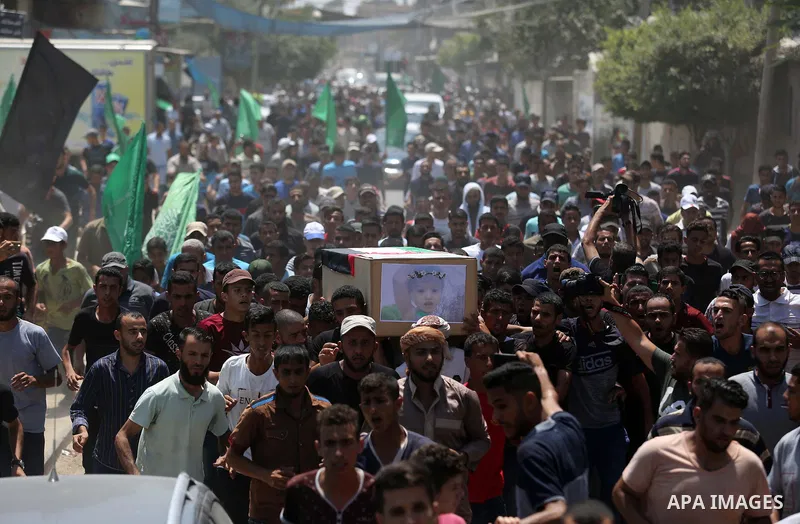 Mourners carry the bodies of Palestinian Enas Khammash 23, and her 18-month-daughter Bayan, during their funeral in Deir Al-Balah in the central Gaza Strip on August 9, 2018, who were killed earlier in an Israeli airstri...