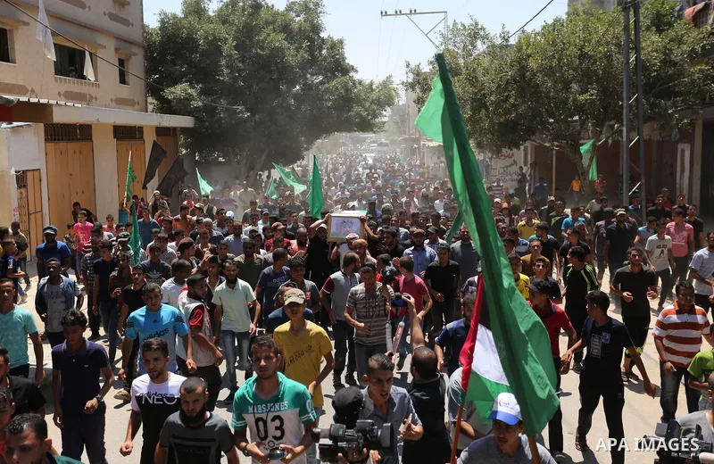 Mourners carry the bodies of Palestinian Enas Khammash 23, and her 18-month-daughter Bayan, during their funeral in Deir Al-Balah in the central Gaza Strip on August 9, 2018, who were killed earlier in an Israeli airstri...