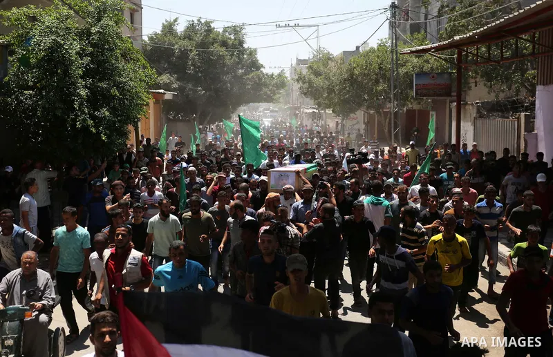 Mourners carry the bodies of Palestinian Enas Khammash 23, and her 18-month-daughter Bayan, during their funeral in Deir Al-Balah in the central Gaza Strip on August 9, 2018, who were killed earlier in an Israeli airstri...