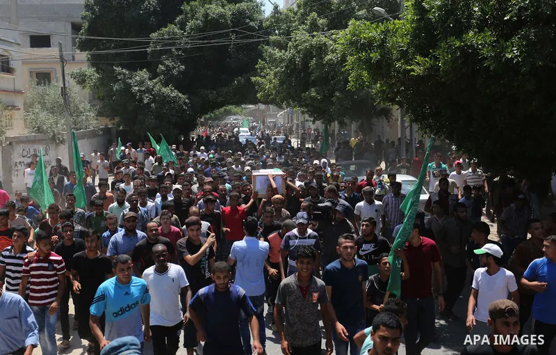 Mourners carry the bodies of Palestinian Enas Khammash 23, and her 18-month-daughter Bayan, during their funeral in Deir Al-Balah in the central Gaza Strip on August 9, 2018, who were killed earlier in an Israeli airstri...
