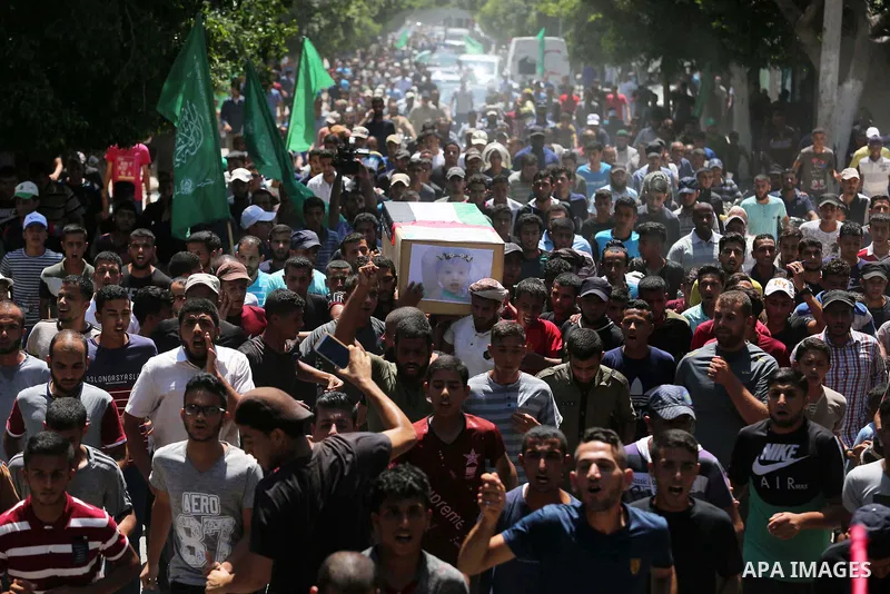 Mourners carry the bodies of Palestinian Enas Khammash 23, and her 18-month-daughter Bayan, during their funeral in Deir Al-Balah in the central Gaza Strip on August 9, 2018, who were killed earlier in an Israeli airstri...