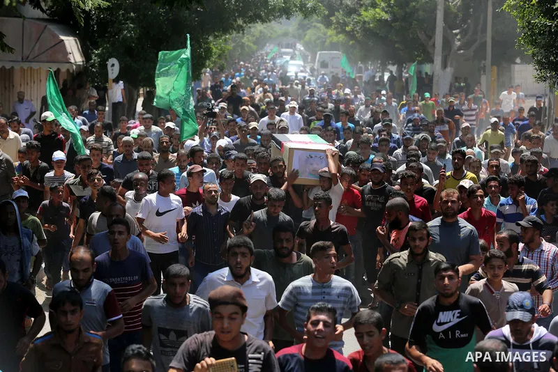 Mourners carry the bodies of Palestinian Enas Khammash 23, and her 18-month-daughter Bayan, during their funeral in Deir Al-Balah in the central Gaza Strip on August 9, 2018, who were killed earlier in an Israeli airstri...