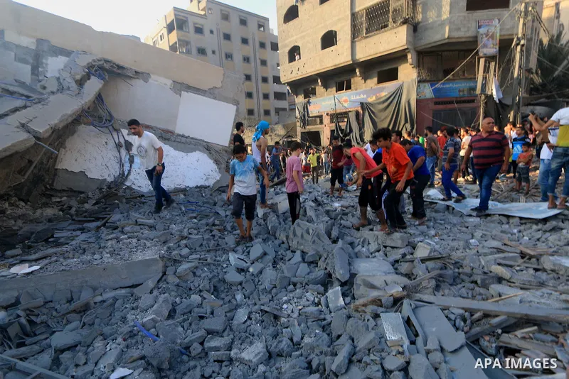 Palestinians inspect the rubble of a building following an Israeli air strike on Gaza City, on August 9, 2018. Photo by Mahmoud Khattab
