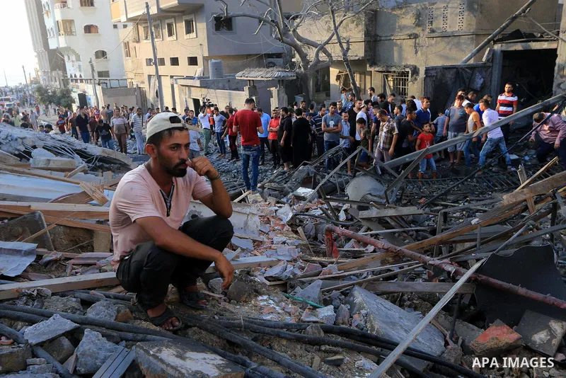 Palestinians inspect the rubble of a building following an Israeli air strike on Gaza City, on August 9, 2018. Photo by Mahmoud Khattab