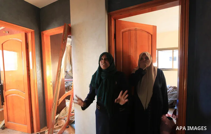 Palestinian women inspect the rubble of a building following an Israeli air strike on Gaza City, on August 9, 2018. Photo by Mahmoud Khattab
