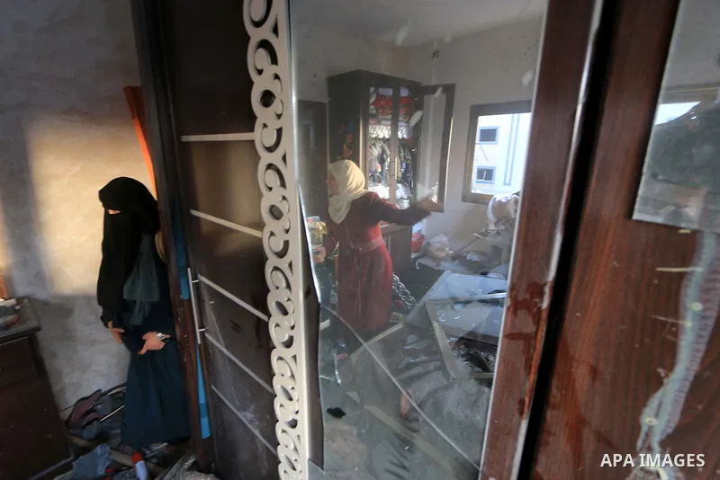 Palestinian women inspect the rubble of a building following an Israeli air strike on Gaza City, on August 9, 2018. Photo by Mahmoud Khattab