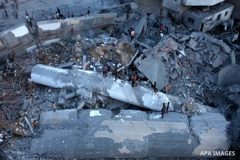 Palestinians inspect the rubble of a building following an Israeli air strike on Gaza City, on August 9, 2018. Photo by Mahmoud Ajour