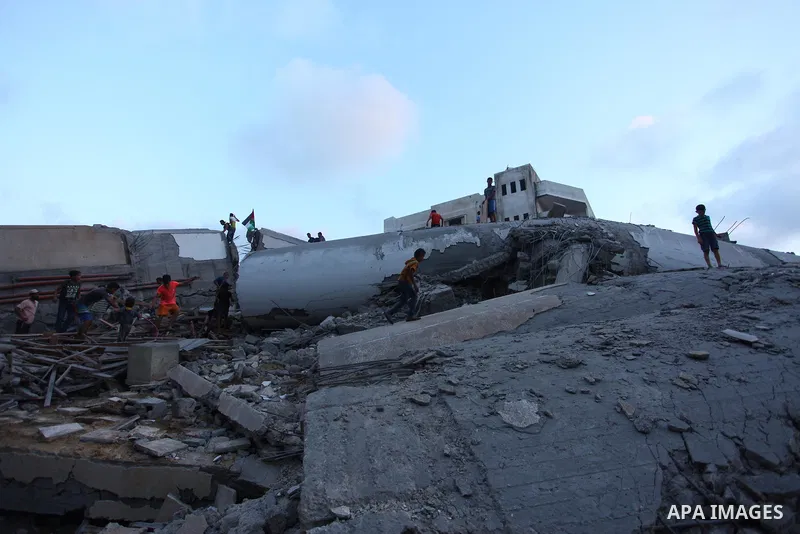 Palestinians inspect the rubble of a building following an Israeli air strike on Gaza City, on August 9, 2018. Photo by Mahmoud Ajour