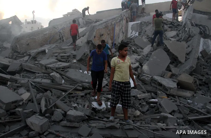 Palestinians inspect the rubble of a building following an Israeli air strike on Gaza City, on August 9, 2018. Photo by Mahmoud Ajour