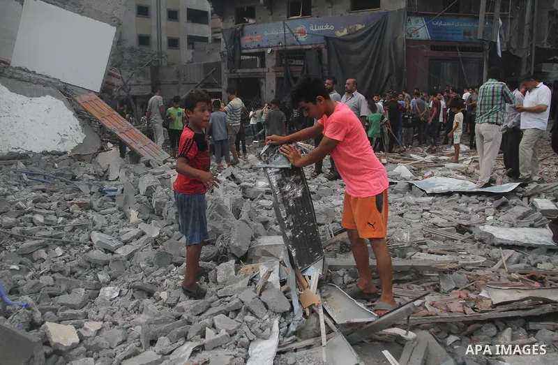 Palestinians inspect the rubble of a building following an Israeli air strike on Gaza City, on August 9, 2018. Photo by Mahmoud Ajour