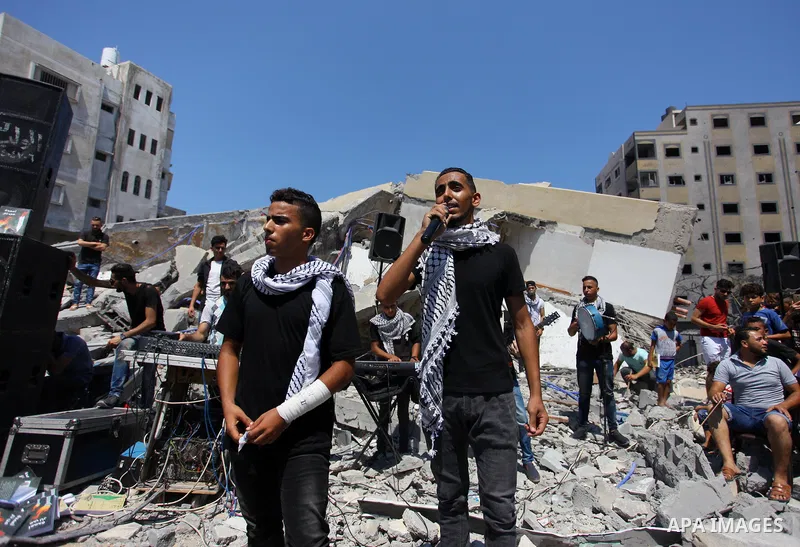 Members of a Palestinian musical band perform on the rubble of Said al-Mishal Cultural Center following an Israeli air strike destroyed it on the previous day, in Gaza city on Aug. 10, 2018. Photo by Mahmoud Ajour