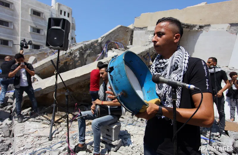 Members of a Palestinian musical band perform on the rubble of Said al-Mishal Cultural Center following an Israeli air strike destroyed it on the previous day, in Gaza city on Aug. 10, 2018. Photo by Mahmoud Ajour