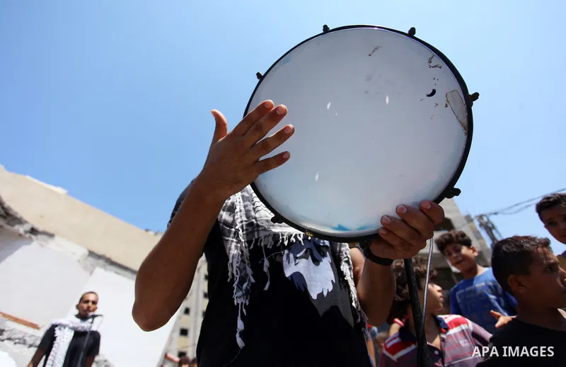 Members of a Palestinian musical band perform on the rubble of Said al-Mishal Cultural Center following an Israeli air strike destroyed it on the previous day, in Gaza city on Aug. 10, 2018. Photo by Mahmoud Ajour