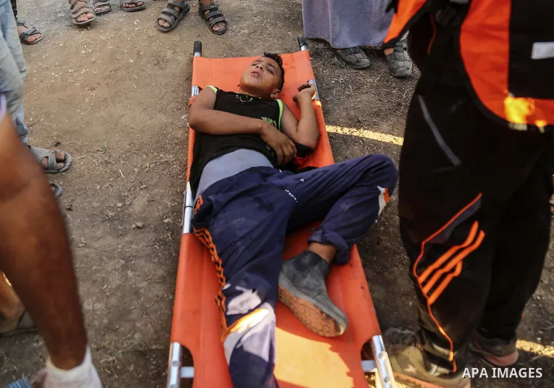 A wounded Palestinian protester receives treatment during clashes with Israeli troops in tents protest where Palestinian demand the right to return to their homeland at the Israel-Gaza border, in east of Gaza City on Aug...